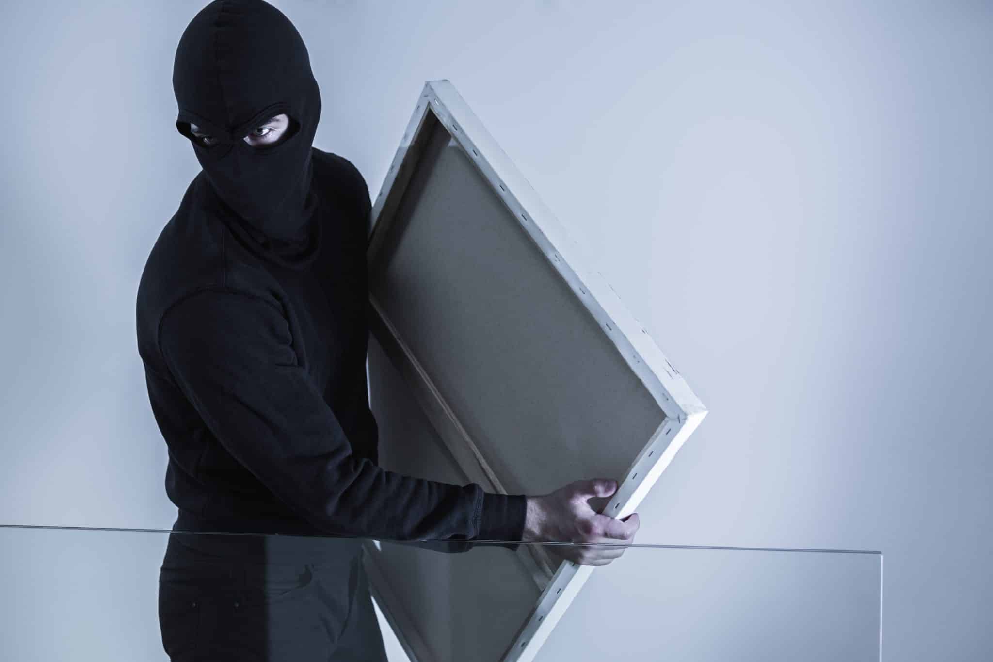 Personne cagoulée retire une toile, ambiance escape game immersive façon Laeris Toulon depuis 2016.