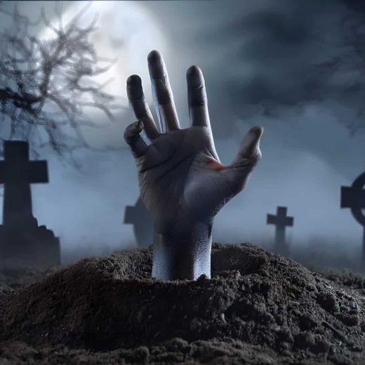 Une main sort d'une tombe, cimetière brumeux la nuit, arbres nus et pierres sous ciel nuageux.