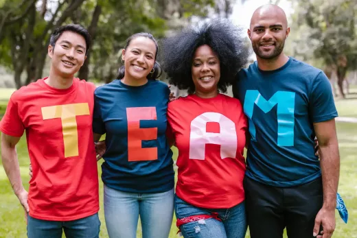 Joueurs en extérieur, T-shirts lettres colorés formant TEAM, esprit convivial et collaboratif.