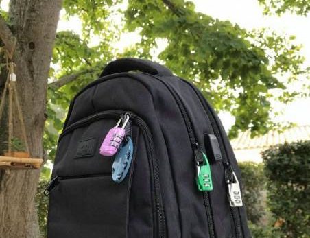 Sac à dos noir, cadenas multicolores, posé dehors près d'arbres. Challenge escape game Laeris Toulon.