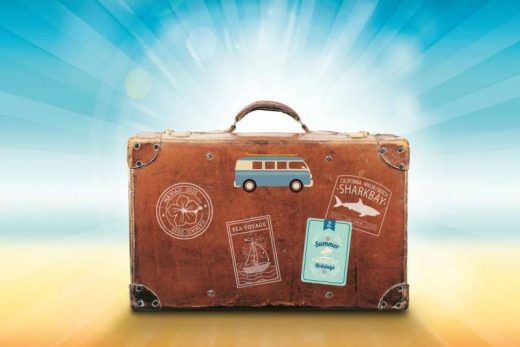 Valise rétro avec stickers sur fond bleu et jaune, parfaite pour une aventure escape game à Toulon.