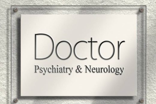 Plaque murale "Doctor Psychiatry & Neurology", lettres métalliques en relief sur fond clair texturé.