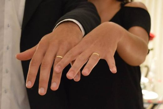Deux mains gauches avec bagues dorées, flou, symbole d'union. Mariage ou fiançailles possibles.