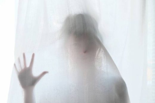 Derrière un voile blanc, une main posée, visage flou - mystère et immersion garantis chez Laeris Toulon.
