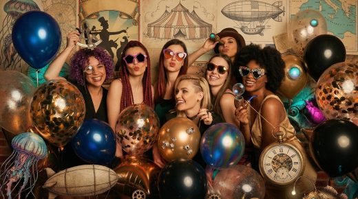 Sept femmes, ballons et déco steampunk devant une fresque vintage aux cartes, montgolfières et horloge.