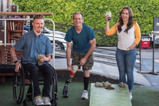 Joueurs avec handicap profitent de la pétanque, tous souriants et détente en plein air.