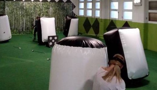 Archery tag en intérieur, obstacles gonflables, terrain vert, idéal pour team building ou anniversaire.
